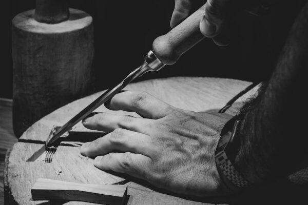 person holding a pen and a round metal container